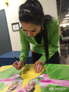 Nach ihrer Tour in Europa und ihrer Rückkehr nach Kanada war die Shen Yun International Company damit beschäftigt, die diesjährigen Poster zu signieren, um sie als Souvenir zu hinterlassen. (Foto: Annie Li, Bühnenprojektion)