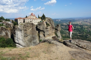 Fast 5.000 Meilen entfernt in Meteora, Griechenland, posiert die Tänzerin Daniella Wollensak vor dem Kloster St. Stephan. Heute ein Nonnenkloster, ist das Gebäude über eine kleine Brücke zugänglich und scheint durch seine Lage auf dem Berg wie in der Luft schwebend. - hier: Griechenland.