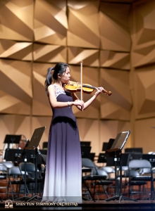 Die schon für das Konzert eingekleidete Geigensolistin Fiona Zheng nutzt die letzte Gelegenheit, auf der Bühne zu üben.